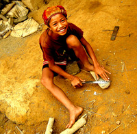 Boy sharpening knife; Ban NaKaang, Laos, 2009