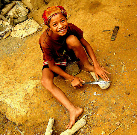 Boy sharpening knife; Ban NaKaang, Laos, 2009